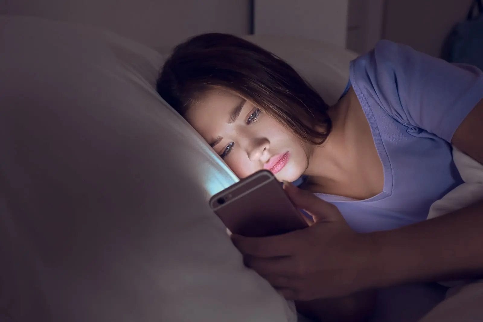 Femme sur son écran dans son lit avant de dormir 