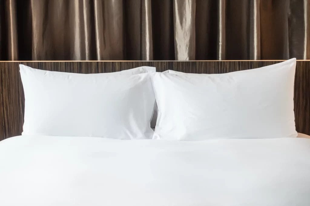 Gros plan sur un lit avec deux oreillers blancs