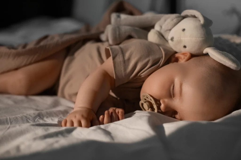 Bébé qui dort avec sa peluche