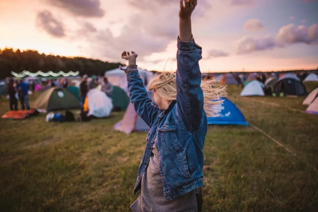Femme faisant la fete dans un festival devant plusieurs tentes
