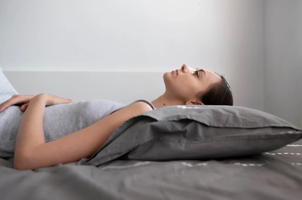 Jeune femme allongée dans son lit avec un esprit apaisé