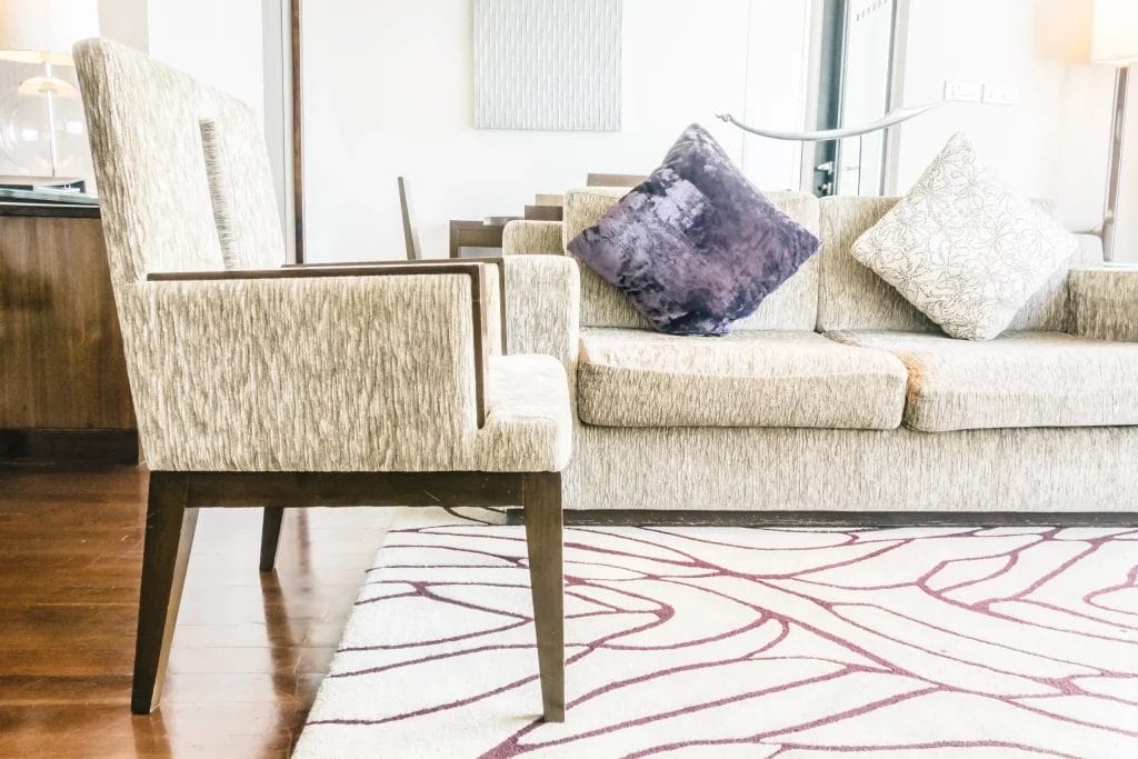 Canapé beige avec coussins décoratifs et fauteuil assorti