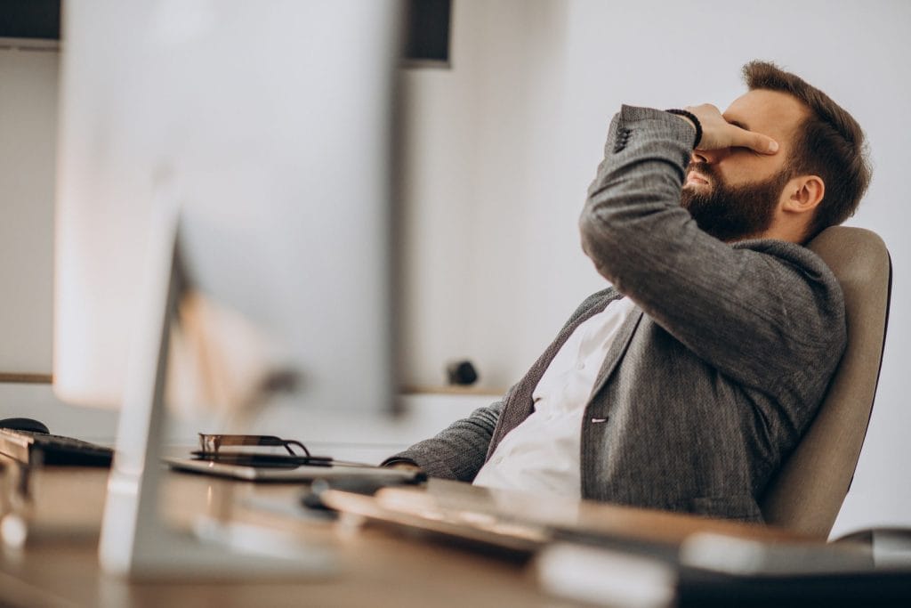 Homme d'affaires fatigué devant son bureau