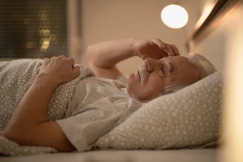 Homme senior n'arrivant pas à dormir dans son lit